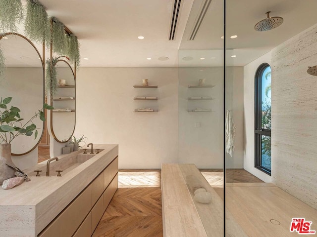 bathroom featuring walk in shower, vanity, and parquet flooring