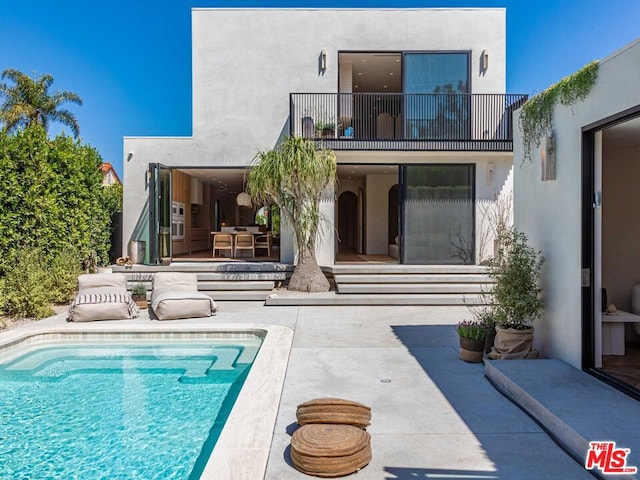 rear view of house featuring a balcony and a patio area