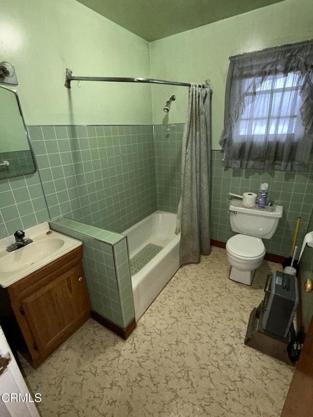 full bathroom featuring toilet, vanity, tile walls, and shower / tub combo with curtain