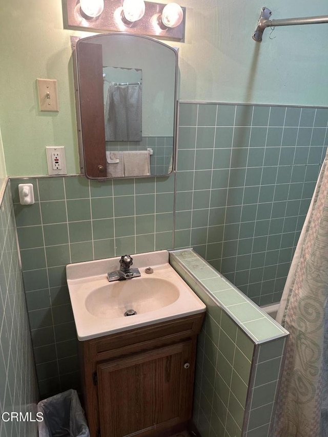 bathroom with vanity and tile walls