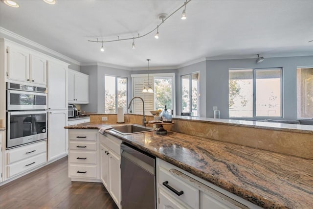 kitchen featuring pendant lighting, white cabinetry, sink, dark stone countertops, and stainless steel appliances