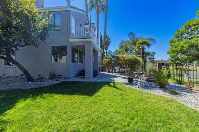 view of yard featuring a patio and a balcony