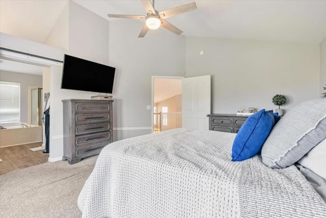 bedroom with carpet floors, high vaulted ceiling, a barn door, and ceiling fan