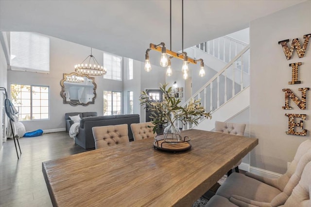 dining space featuring a high ceiling, wood-type flooring, and a notable chandelier