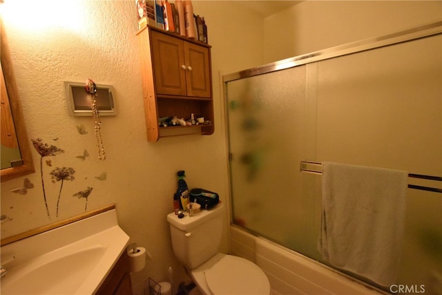 full bathroom with enclosed tub / shower combo, vanity, and toilet