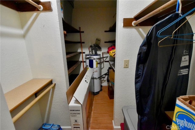 spacious closet with wood-type flooring and secured water heater