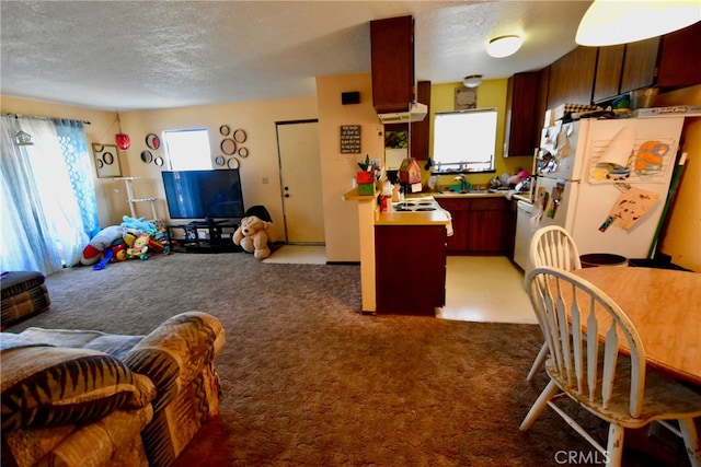 kitchen featuring white refrigerator, carpet flooring, and a textured ceiling