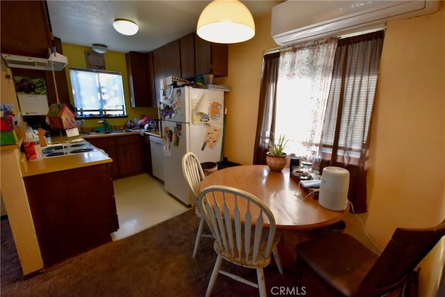 kitchen featuring an AC wall unit, white appliances, and sink