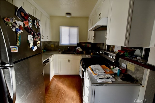 kitchen with appliances with stainless steel finishes, light hardwood / wood-style floors, sink, and white cabinets