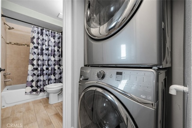 washroom with light wood-type flooring and stacked washing maching and dryer