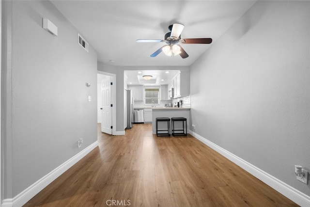 unfurnished living room with ceiling fan and light hardwood / wood-style flooring