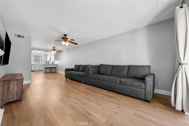 living room with ceiling fan and light hardwood / wood-style floors