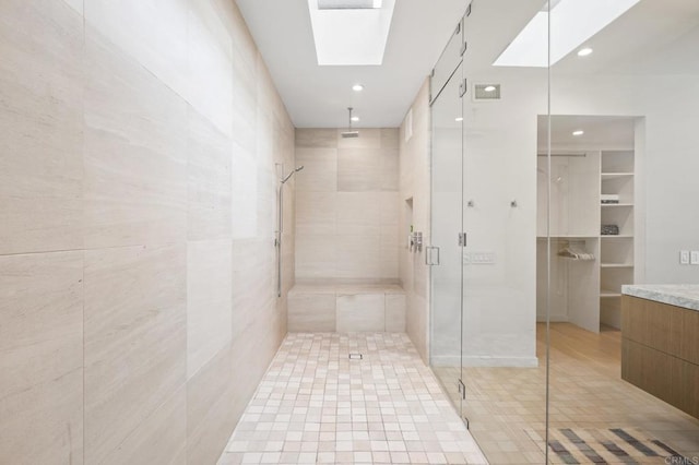 bathroom with tile walls, vanity, and an enclosed shower