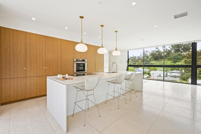 kitchen with a large island, a breakfast bar, sink, wooden walls, and decorative light fixtures