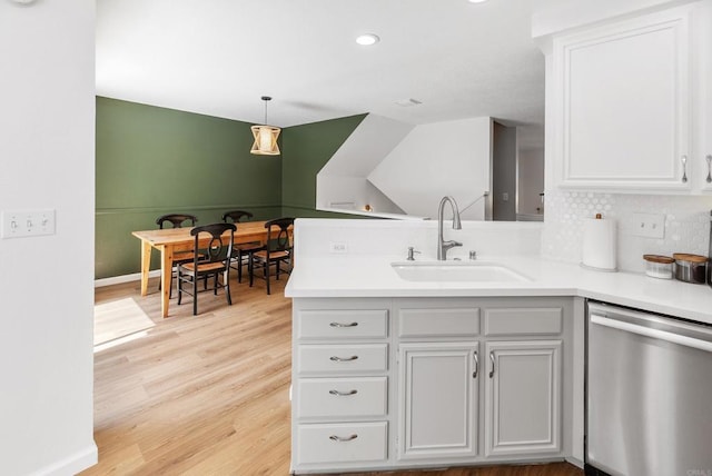 kitchen featuring white cabinetry, dishwasher, sink, tasteful backsplash, and pendant lighting