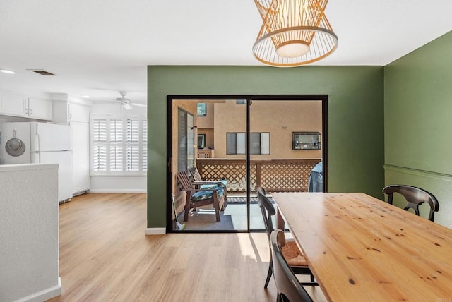 dining space featuring ceiling fan and light wood-type flooring