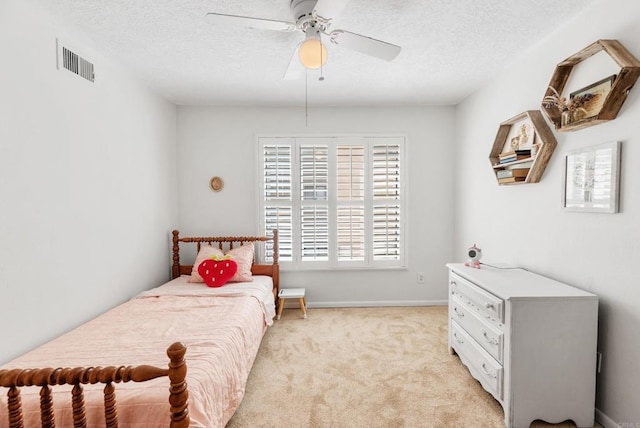 carpeted bedroom featuring a textured ceiling and ceiling fan