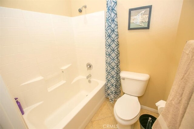 bathroom featuring shower / tub combo with curtain, tile patterned floors, and toilet