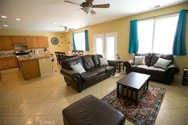 living room featuring french doors, ceiling fan, sink, and light tile patterned floors