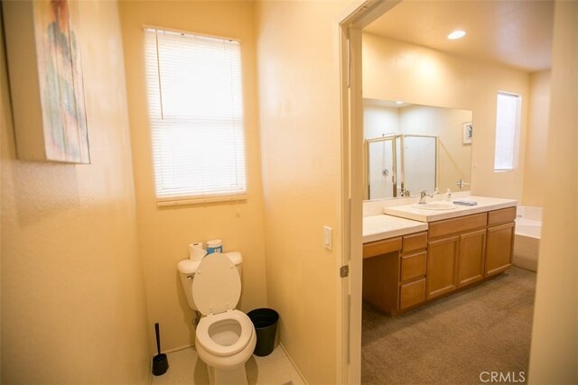 bathroom with walk in shower, vanity, and toilet