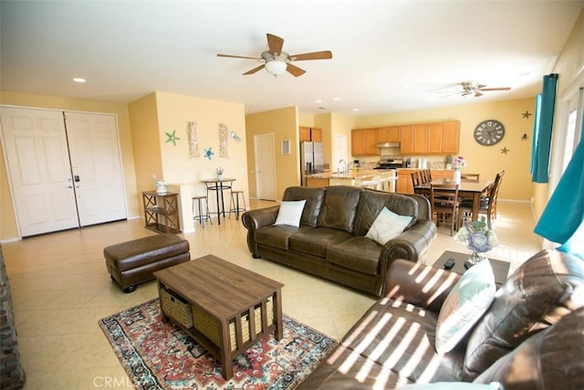 living room with light tile patterned flooring, ceiling fan, and sink