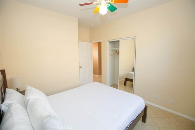 tiled bedroom featuring ceiling fan and a closet