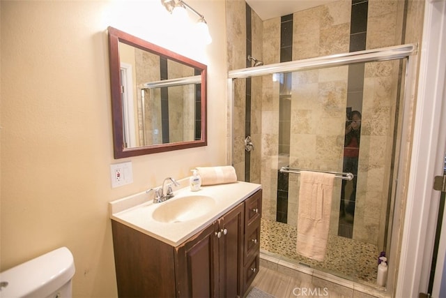 bathroom featuring walk in shower, vanity, and toilet