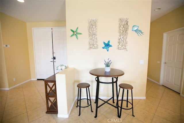 interior space featuring light tile patterned floors and a breakfast bar