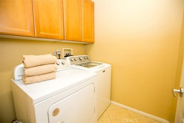 washroom with cabinets, washer and dryer, and light tile patterned floors