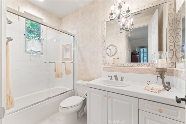 full bathroom with tile patterned flooring, a chandelier, combined bath / shower with glass door, vanity, and toilet