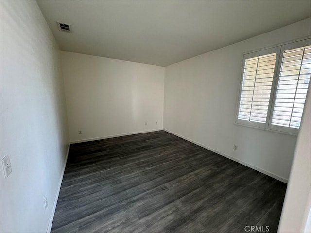 spare room with dark wood-type flooring