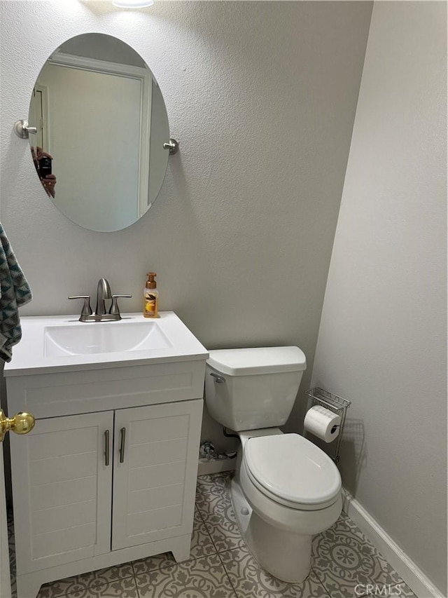 bathroom featuring tile patterned flooring, vanity, and toilet