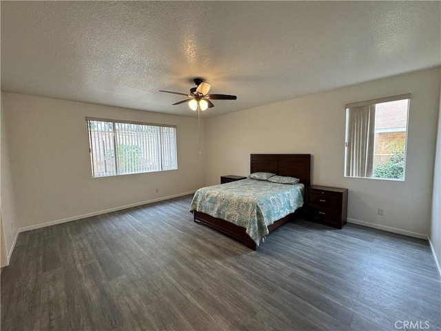 unfurnished bedroom featuring multiple windows, ceiling fan, and dark hardwood / wood-style floors