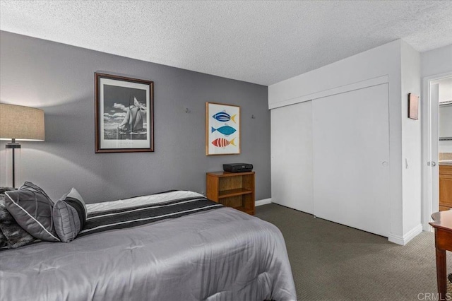 carpeted bedroom with a closet and a textured ceiling