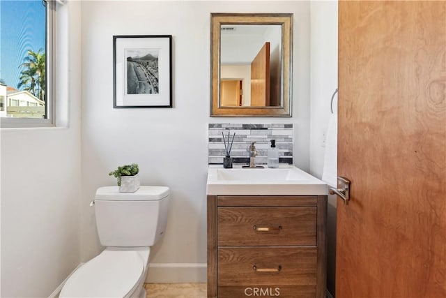 bathroom with vanity, toilet, and backsplash