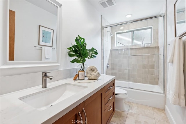 full bathroom featuring tile patterned floors, vanity, toilet, and combined bath / shower with glass door