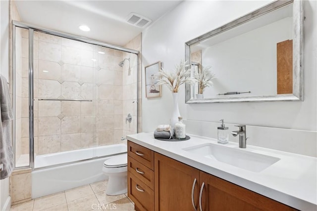 full bathroom featuring combined bath / shower with glass door, vanity, toilet, and tile patterned flooring