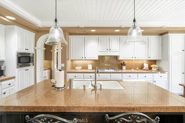 kitchen featuring hanging light fixtures, white gas cooktop, stainless steel microwave, and a large island