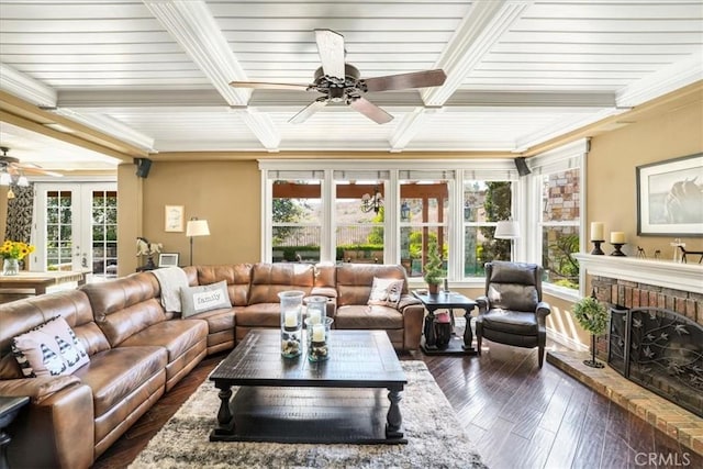 sunroom / solarium featuring beam ceiling, a fireplace, a wealth of natural light, and french doors