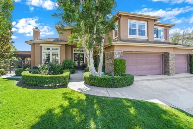 view of front of house featuring a garage, a front yard, and french doors