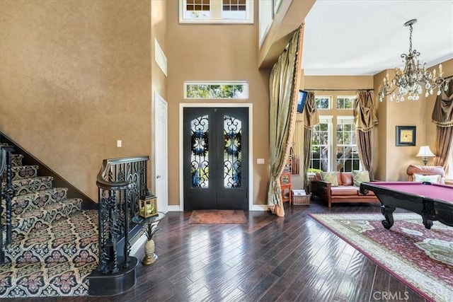 foyer entrance featuring a chandelier, french doors, dark hardwood / wood-style flooring, and pool table