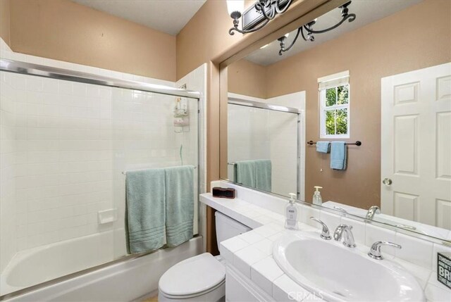 full bathroom with vanity, toilet, and bath / shower combo with glass door