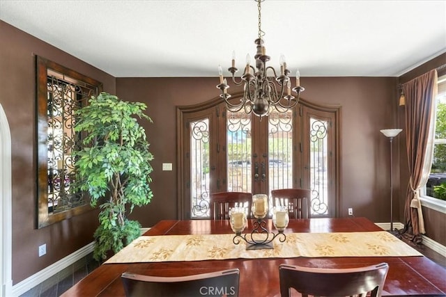 dining area featuring french doors and a chandelier