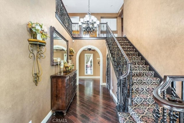 foyer entrance with dark hardwood / wood-style flooring and a chandelier