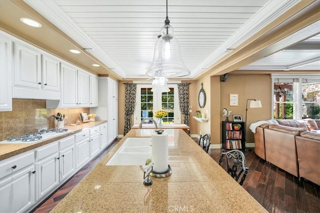 kitchen with dark hardwood / wood-style flooring, white cabinetry, hanging light fixtures, and a wealth of natural light