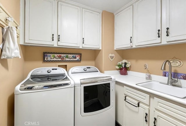 laundry area with cabinets, separate washer and dryer, and sink