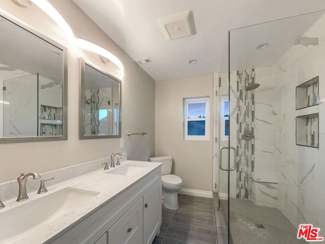 bathroom featuring tile patterned floors, vanity, toilet, and walk in shower