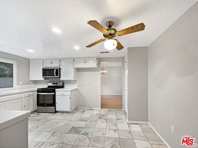 kitchen featuring white cabinets, ceiling fan with notable chandelier, and appliances with stainless steel finishes