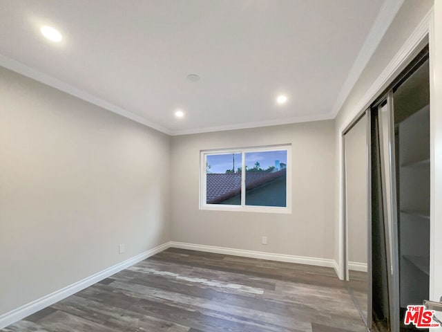 unfurnished bedroom featuring dark hardwood / wood-style floors, a closet, and ornamental molding