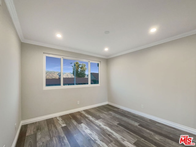 spare room with dark wood-type flooring and ornamental molding